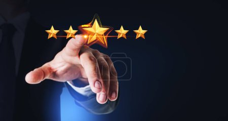 Photo for Hand of unrecognizable businessman giving five star rank over dark blue background. Concept of giving service feedback and rating. Mock up - Royalty Free Image