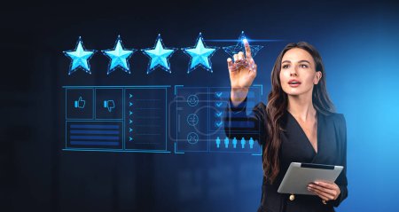 Photo for Businesswoman with tablet in hand, finger touch virtual screen with feedback and rating dashboard, giving five stars for customer service. Concept of online review and satisfaction - Royalty Free Image