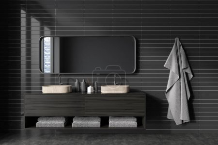 Foto de Vista frontal en el interior del baño oscuro con espejo grande, ventana panorámica con vista a la ciudad en reflexión, lavabos, paredes de baldosas grises, suelo de hormigón, estantes con toallas, grifo. renderizado 3d - Imagen libre de derechos