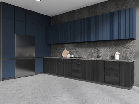 Foto de Esquina de elegante cocina con paredes grises, suelo de hormigón, armarios azules, armarios de madera oscura y nevera grande con puerta de acero. renderizado 3d - Imagen libre de derechos