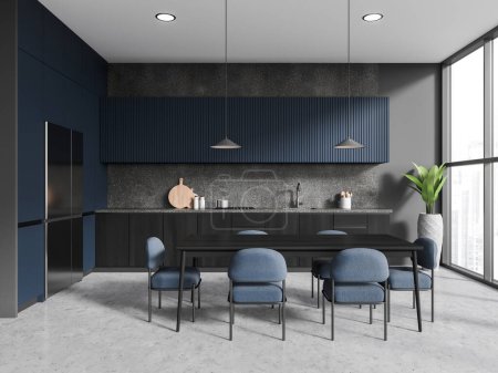 Téléchargez les photos : Intérieur d'une cuisine élégante avec murs gris, sol en béton, placards bleus, réfrigérateur et longue table à manger avec chaises bleues. Rendu 3d - en image libre de droit