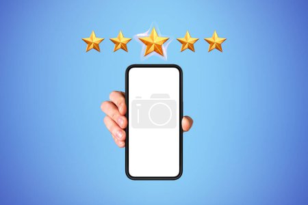 Photo for Man hand holding a mockup phone screen, blue background. Five gold stars, high rating and customer service. Concept of review and feedback - Royalty Free Image