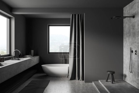 Téléchargez les photos : Intérieur salle de bain sombre avec baignoire et douche, lavabo près de la fenêtre panoramique sur vue campagne. Rideaux et tabouret sur podium en béton gris. rendu 3D - en image libre de droit