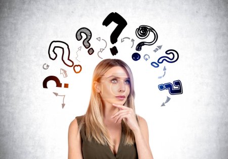 Photo for Businesswoman portrait with hand to chin, thoughtful look, searching for answers. Doodle question marks with arrows drawn on grey concrete background. Concept of plan and idea - Royalty Free Image