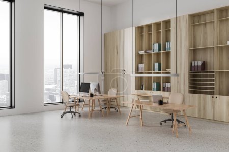 Ecke des modernen CEO-Büros mit weißen Wänden, Betonboden, zwei Computertischen und einem hölzernen Bücherregal mit Ordnern. 3D-Darstellung