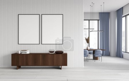 Foto de Interior del elegante comedor con paredes de madera blanca y blanca, mesa larga con sillas azules y cómoda de madera con dos carteles verticales simulados encima. renderizado 3d - Imagen libre de derechos