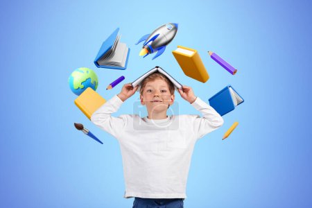 Téléchargez les photos : Enfant souriant regardant la caméra avec livre sur la tête, différentes icônes éducatives avec livres et fusée volant, fond bleu. Concept d'apprentissage, de connaissance et de développement en ligne - en image libre de droit