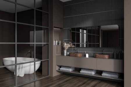 Photo for Dark bathroom interior with double sink and bathtub behind glass doors, side view. Brown dresser with bath accessories and minimalist art decoration. 3D rendering - Royalty Free Image
