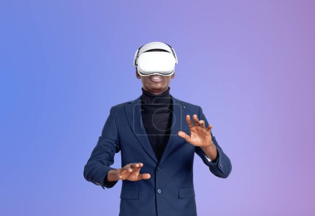 Téléchargez les photos : Homme d'affaires africain portant des lunettes vr casque, doigts touchant quelque chose sur le dégradé violet. Concept de technologie métaverse et futuriste. Espace de copie - en image libre de droit