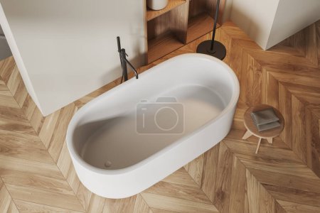 Téléchargez les photos : Vue de dessus de l'intérieur de la salle de bain minimaliste avec baignoire sur plancher de bois franc. Coin de bain confortable hôtel avec tabouret et serviette, étagère avec accessoires. rendu 3D - en image libre de droit