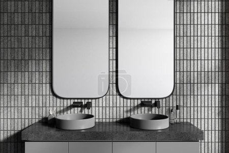 Foto de Interior de elegante cuarto de baño con paredes de baldosas grises y dos lavabos redondos de pie en el gabinete gris con dos espejos verticales por encima de ellos. renderizado 3d - Imagen libre de derechos