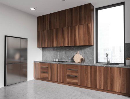 Photo for White stylish kitchen interior with sink and kitchenware on deck. Cooking corner with fridge and wooden shelves, grey concrete floor. Panoramic window on skyscrapers. 3D rendering - Royalty Free Image