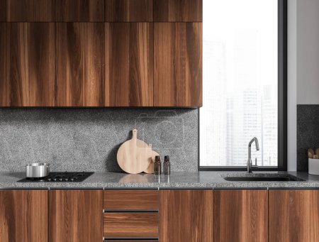 Photo for Interior of modern kitchen with gray walls, dark wooden cupboards and dark wooden cabinets with built in sink standing under window with cityscape. 3d rendering - Royalty Free Image