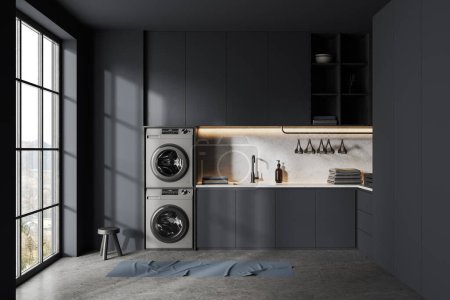 Photo for Dark laundry interior with hidden shelves, washing machines and appliances with sink and towel. Modern apartment with panoramic window on countryside, grey concrete floor. 3D rendering - Royalty Free Image