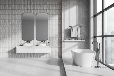 Photo for Interior of modern bathroom with white tile walls, concrete floor, comfortable white bathtub standing near panoramic window and double sink with two vertical mirrors. 3d rendering - Royalty Free Image
