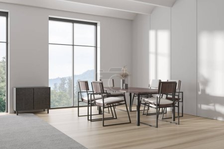 Foto de Interior blanco con mesa y sillas, vista lateral, suelo de madera. Ventana panorámica con vistas al campo. Comedor minimalista con cajón. Renderizado 3D - Imagen libre de derechos