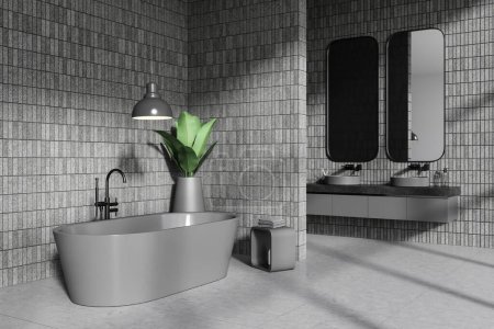 Téléchargez les photos : Coin de salle de bain élégante avec des murs de tuiles grises, sol en béton, baignoire grise confortable et double lavabo avec deux miroirs verticaux. Rendu 3d - en image libre de droit
