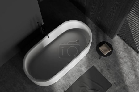 Téléchargez les photos : Vue de dessus de la salle de bain élégante avec des murs en bois gris et sombre, sol en béton et baignoire blanche confortable remplie d'eau. Rendu 3d - en image libre de droit