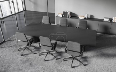 Téléchargez les photos : Vue de dessus de la salle de réunion de bureau élégante avec des murs gris foncé, sol moquette gris, longue table de conférence et chaises grises. Rendu 3d - en image libre de droit