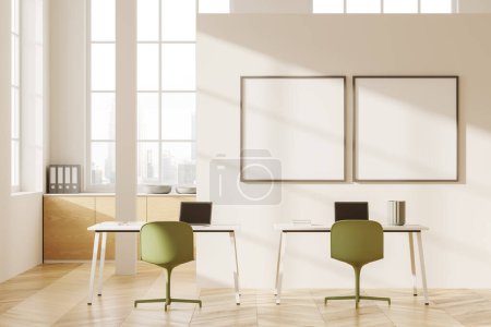 Photo for Interior of modern open space office with white walls, wooden floor, white computer tables with green chairs and laptops and wooden cabinets. Two square mock up posters. 3d rendering - Royalty Free Image