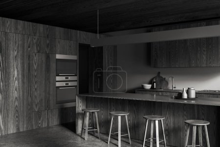 Foto de Esquina de la elegante cocina con paredes grises, suelo de hormigón, armarios de madera oscura con cocina y fregadero incorporados y barra de bar de madera oscura con taburetes. renderizado 3d - Imagen libre de derechos
