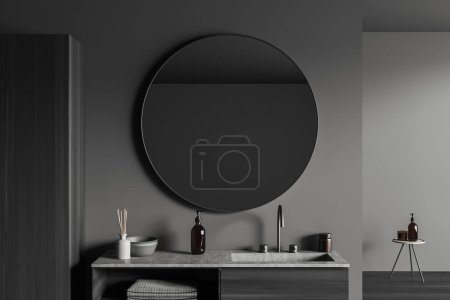 Foto de Interior de baño oscuro con lavabo y espejo redondo. Vestidor con accesorios de baño y decoración, taburete con botella de jabón. Renderizado 3D - Imagen libre de derechos