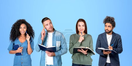 Photo for Portrait of four diverse college students with notebooks and pens standing in row over blue background. Concept of teamwork, brainstorming, creativity and education - Royalty Free Image