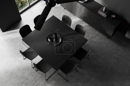 Photo for Top view of stylish dining room with gray walls, concrete floor, square dining table with chairs, dark wooden dresser with books and windows. 3d rendering - Royalty Free Image