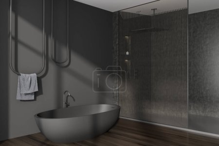 Téléchargez les photos : Intérieur salle de bain sombre avec baignoire et serviette sur rail, vue latérale, douche de luxe avec cloison en verre. Coin de bain moderne avec parquet. rendu 3D - en image libre de droit