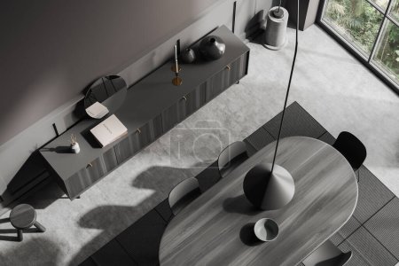 Photo for Top view of dark living room interior with dining table and chairs, carpet on grey concrete floor. Drawer with decoration and panoramic window on tropics. 3D rendering - Royalty Free Image