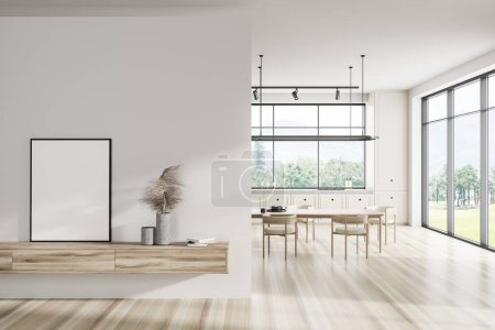 Foto de Interior de la cocina blanca con mesa de comedor y sillas en el suelo de madera, zona de cocina y ventana panorámica en el campo. Cajón con decoración y póster de maqueta. Renderizado 3D - Imagen libre de derechos