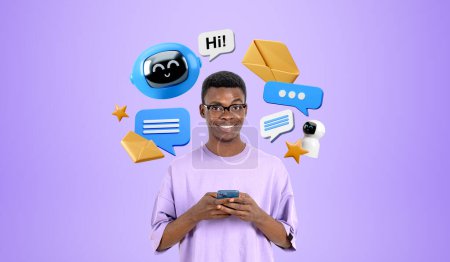 Téléchargez les photos : Sourire homme africain travaillant avec téléphone et chat bot. L'IA aide à générer des idées et du texte. Robot icônes avec bulles vocales. Concept d'assistant virtuel et de communication en ligne - en image libre de droit