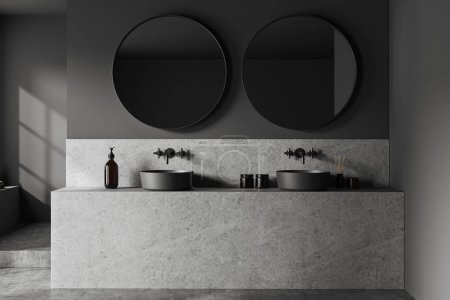 Téléchargez les photos : Intérieur de la salle de bain élégante avec des murs gris, sol en béton, lavabo double gris debout sur une armoire en pierre massive et deux miroirs ronds. Rendu 3d - en image libre de droit