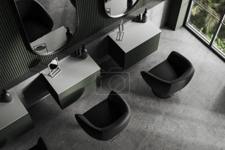 Téléchargez les photos : Vue de dessus du salon de coiffure élégant avec des murs vert foncé, sol en béton et rangée de chaises de client gris avec de petites tables et de grands miroirs. Rendu 3d - en image libre de droit