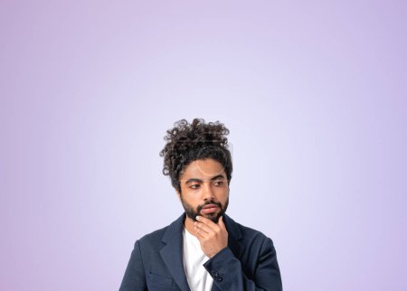 Photo for Arab businessman portrait with concentrated and pensive look, hand to chin. Concept of idea and brainstorm. Copy space empty purple wall - Royalty Free Image