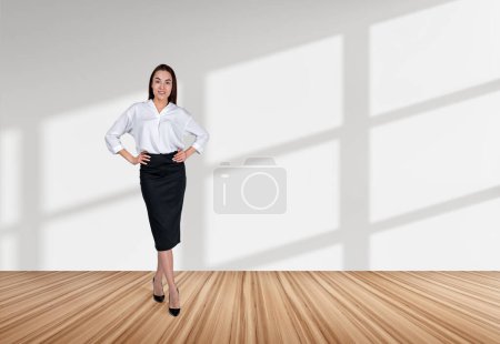 Photo for Businesswoman with hands on waist full length on hardwood floor. Confident manager looking at the camera, copy space white background. Concept of strategy and development - Royalty Free Image