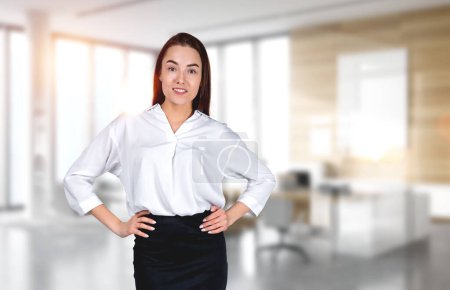 Photo for Businesswoman confident look with hands on waist looking at the camera, blurred background of ceo room. Concept of consulting and finance - Royalty Free Image