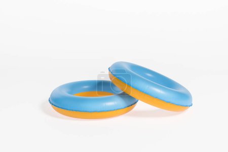 Téléchargez les photos : Deux anneaux de bain colorés, accessoire d'été gonflable sur fond blanc vide. Concept de loisirs et de voyages. rendu 3D - en image libre de droit