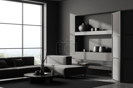 Photo for Dark living room interior with sofa and coffee table, side view, carpet on grey concrete floor. Shelf with books and decor, panoramic window on countryside. 3D rendering - Royalty Free Image