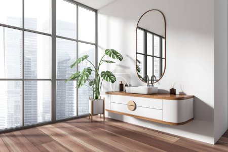 Photo for White bathroom interior with sink and oval mirror, side view, big plant in the corner on hardwood floor. Panoramic window on Singapore skyscrapers. 3D rendering - Royalty Free Image