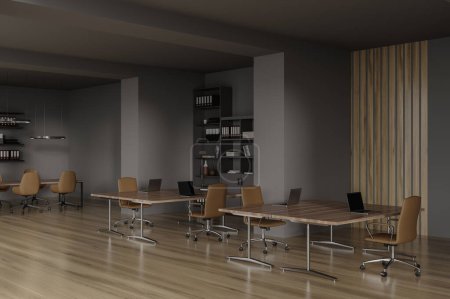Téléchargez les photos : Coin de bureau élégant avec des murs gris et en bois, sol en bois foncé, rangée de bureaux d'ordinateur et table de conférence avec des chaises en arrière-plan. Rendu 3d - en image libre de droit