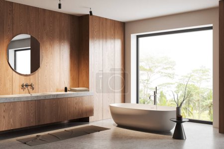 Photo for Corner of modern bathroom with white and light wooden walls, concrete floor, comfortable white bathtub standing near window and sink with round mirror. 3d rendering - Royalty Free Image