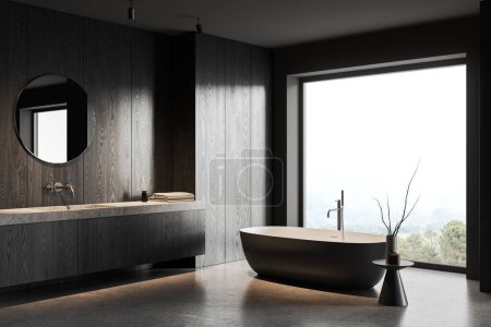 Photo for Corner of stylish bathroom with gray and dark wooden walls, concrete floor, comfortable gray bathtub standing near window and sink with round mirror. 3d rendering - Royalty Free Image