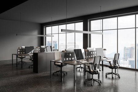 Foto de Esquina de elegante oficina de espacio abierto con paredes grises, piso de hormigón, fila de mesas de ordenador con sillas grises y grandes ventanales con paisaje urbano. renderizado 3d - Imagen libre de derechos