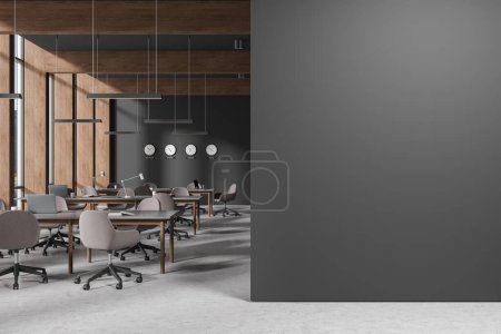 Photo for Interior of stylish coworking office with gray and dark wooden walls, concrete floor, row of big gray tables with brown chairs, dark wooden bookshelves and clocks. Blank copy space wall. 3d rendering - Royalty Free Image