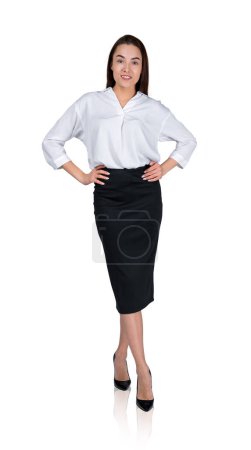 Téléchargez les photos : Femme d'affaires en chemise et jupe blanche, les mains sur la taille en regardant la caméra, isolée sur fond blanc. Concept de conseil et de carrière en entreprise - en image libre de droit