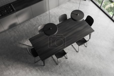 Téléchargez les photos : Vue de dessus de l'intérieur de la cuisine sombre avec table à manger et chaises en bois. Fenêtre panoramique sur les tropiques. Coin cuisine de l'hôtel au sol en béton gris. rendu 3D - en image libre de droit