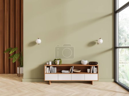 Téléchargez les photos : Maison verte salon intérieur avec buffet en bois et blanc, livres et décoration élégante avec plante sur plancher de bois franc. Fenêtre panoramique sur vue tropicale. Maquette mur vide. rendu 3D - en image libre de droit