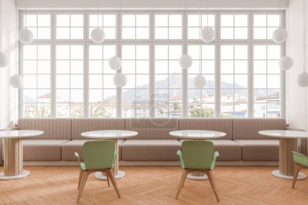 Téléchargez les photos : Restaurant intérieur minimaliste avec chaises vertes et table ronde en rangée. Café confortable salle à manger avec canapé beige le long de la fenêtre panoramique sur la campagne. rendu 3D - en image libre de droit