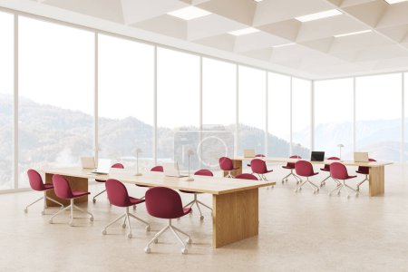 Téléchargez les photos : Intérieur d'une élégante salle de lecture de bibliothèque publique avec sol en béton, fenêtres panoramiques et deux longues tables avec chaises rouges et ordinateurs portables. Rendu 3d - en image libre de droit